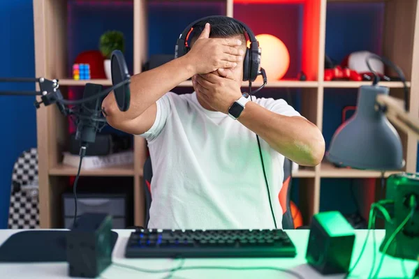 Молодой Латиноамериканец Играющий Видеоигры Закрывая Глаза Рот Руками Удивлен Шокирован — стоковое фото