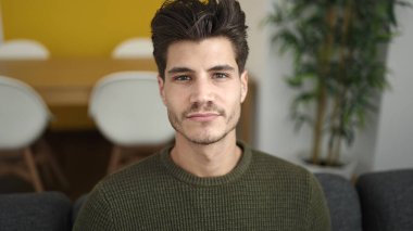 Evdeki rahat ifadesiyle koltukta oturan İspanyol genç adam.