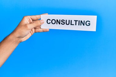 Kafkasyalı bir adam elinde kağıt tutarken mavi arka planda danışmanlık yapıyor.