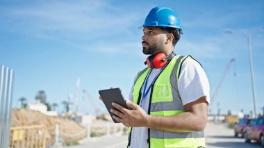 Sokakta dokunmatik ped kullanan Afrikalı Amerikalı bir inşaatçı.