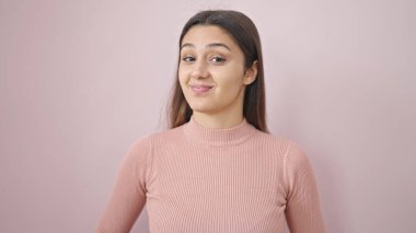 Young beautiful hispanic woman smiling confident standing over isolated pink background