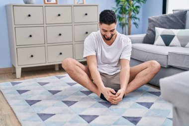 Genç Arap adam gülümsüyor, evinde geriniyor.