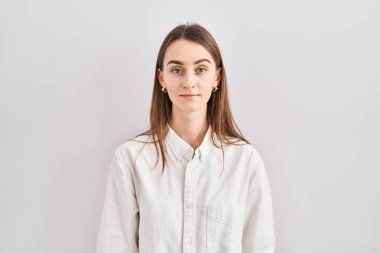 Young caucasian woman standing over isolated background relaxed with serious expression on face. simple and natural looking at the camera. 