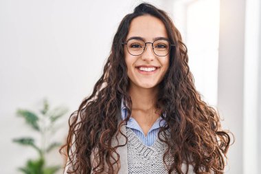 Genç İspanyol iş kadını ofiste kendine güvenen bir gülümseme