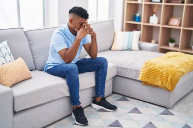 Evdeki kanepede oturan genç latin adam strese girdi.