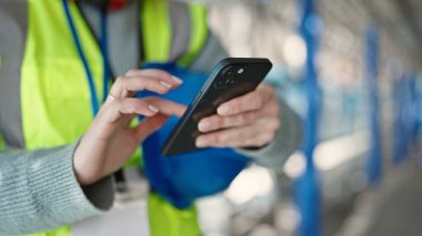 Sokakta akıllı telefon kullanan genç sarışın müteahhit.