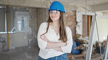 Şantiyede kolları çapraz duran, güler yüzlü, güzel İspanyol kadın müteahhit.