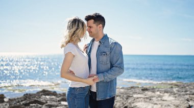 Man and woman couple smiling confident dancing at seaside