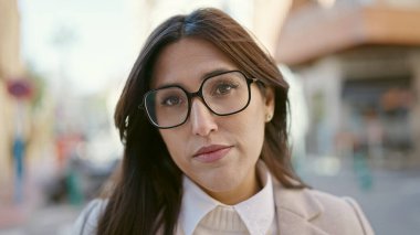 Sokakta ciddi bir ifadeyle duran genç, güzel İspanyol kadın.