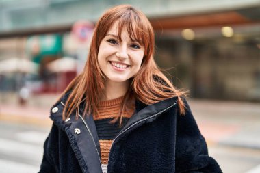 Sokakta kendinden emin gülümseyen genç bir kadın