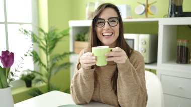 Güzel İspanyol kadın yemek masasında kahve içiyor.