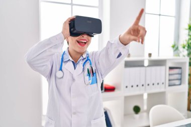Genç, güzel İspanyol kadın doktor klinikte sanal gerçeklik gözlüğü kullanıyor.