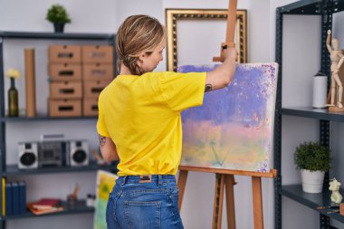 Young blonde woman artist smiling confident looking draw at art studio