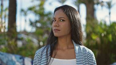 African american woman standing with serious expression at park