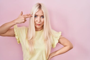 Kafkasyalı kadın pembe arka planda durup ateş ediyor ve kendini öldürüyor. Silah gibi elini ve parmaklarını işaret ediyor. İntihar hareketi.. 