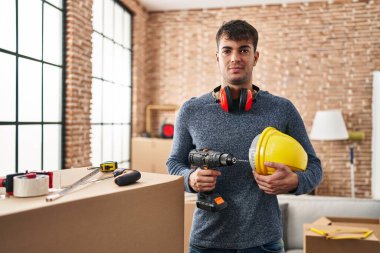 Evdeki tadilatta çalışan genç İspanyol adam yüzünde ciddi bir ifadeyle rahatladı. Basit ve doğal bir şekilde kameraya bakıyorsun.. 