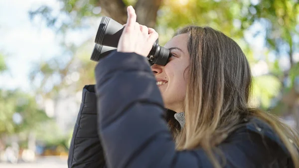 年轻的高加索女人在公园用双筒望远镜充满自信地微笑 — 图库照片