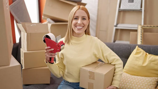 Ung Blond Kvinna Håller Paket Och Förpackningsmaskin Nytt Hem — Stockfoto