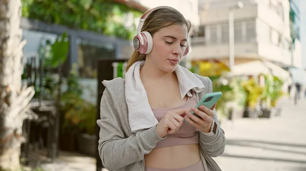 Νεαρή Ξανθιά Γυναίκα Που Φοράει Αθλητικά Ακούγοντας Μουσική Στο Δρόμο — Φωτογραφία Αρχείου