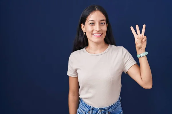 Jonge Latino Vrouw Staande Blauwe Achtergrond Tonen Wijzen Met Vingers — Stockfoto
