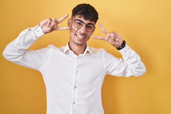 Young Hispanic Man Standing Yellow Background Doing Peace Symbol Fingers — Stock Photo, Image