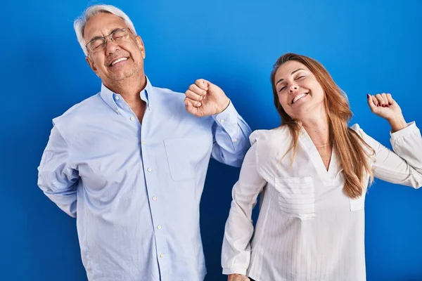 Middle Age Hispanic Couple Standing Blue Background Stretching Back Tired — Stock Photo, Image