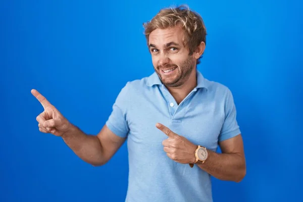 Homme Caucasien Debout Sur Fond Bleu Pointant Côté Inquiet Nerveux — Photo