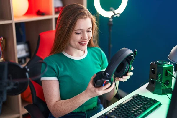 Young Redhead Woman Streamer Smiling Confident Holding Headphones Gaming Room — Stockfoto