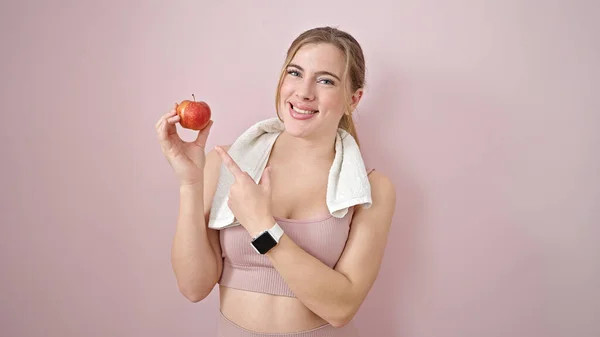 Ung Blond Kvinna Bär Sportkläder Pekar Äpple Över Isolerade Rosa — Stockfoto