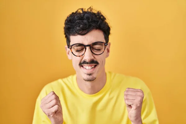 Homem Hispânico Usando Óculos Sobre Fundo Amarelo Animado Para Sucesso — Fotografia de Stock