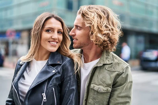 Erkek ve kadın bir arada durarak gülümsüyor.