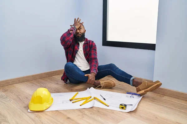 African American Man Sitting Floor New Home Looking Blueprints Surprised — Stock Photo, Image