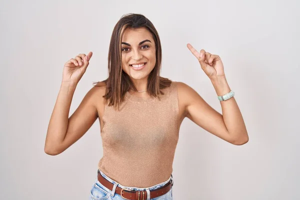 Young Hispanic Woman Standing White Background Smiling Amazed Surprised Pointing — Stock Fotó