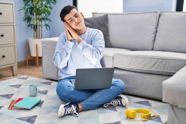 stock image Non binary person studying using computer laptop sitting on the floor sleeping tired dreaming and posing with hands together while smiling with closed eyes. 