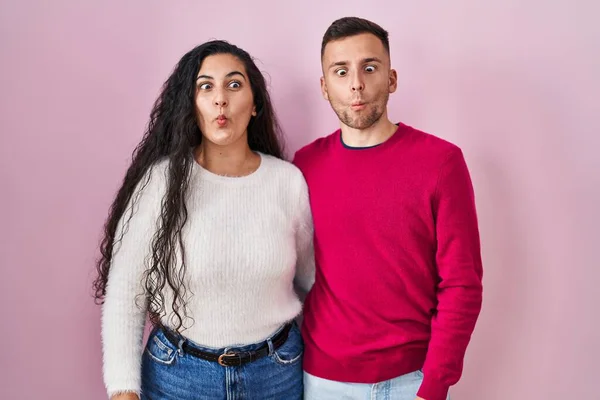 Junges Hispanisches Paar Das Vor Rosa Hintergrund Steht Und Fischgesicht — Stockfoto