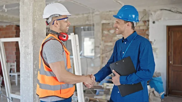 两名建筑商和建筑师在建筑工地握手 — 图库照片