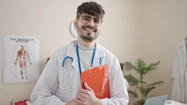 Joven Médico Hispano Sonriendo Confiado Pie Clínica —  Fotos de Stock