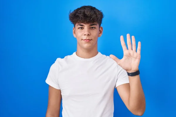 Латиноамериканец Стоящий Синем Фоне Показывающий Пальцами Номер Пять Улыбаясь Уверенно — стоковое фото