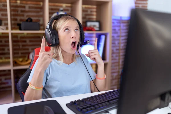 Young Caucasian Woman Playing Video Games Wearing Headphones Amazed Surprised — Stock Photo, Image
