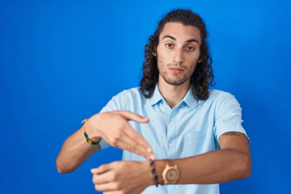 Young Hispanic Man Standing Blue Background Hurry Pointing Watch Time — Stockfoto