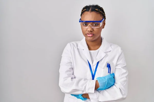 头戴辫子的非洲裔美国妇女身穿科学家长袍 头戴怀疑和紧张的衣服 双手交叉 满脸不赞成的表情 消极的人 — 图库照片