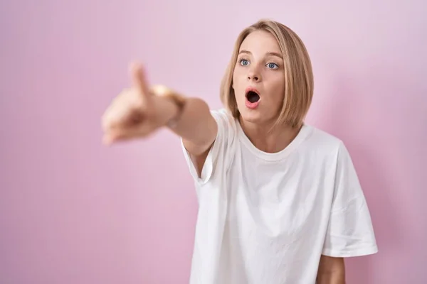 Young Caucasian Woman Standing Pink Background Pointing Finger Surprised Ahead — Stock Photo, Image