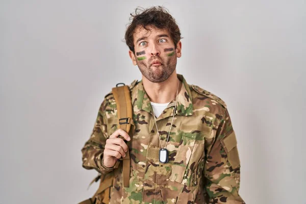 Hispanic Young Man Wearing Camouflage Army Uniform Making Fish Face — Foto de Stock