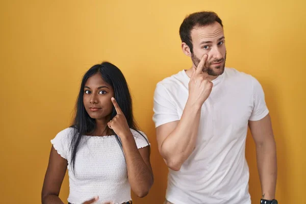Interracial Couple Standing Yellow Background Pointing Eye Watching You Gesture — Stock Photo, Image