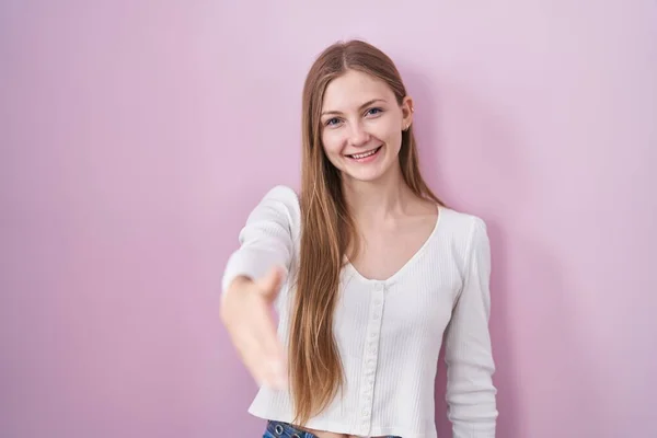 Joven Mujer Caucásica Pie Sobre Fondo Rosa Sonriente Amistoso Ofreciendo —  Fotos de Stock