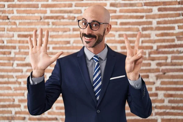 秃头的男人 留着胡子 身穿商务服装 戴着眼镜 用七号手指指尖 面带微笑 自信而快乐 — 图库照片