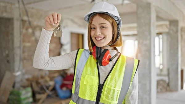 年轻的金发女建筑师微笑着 自信地拿着建筑工地新家的钥匙 — 图库照片