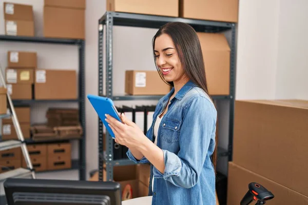 Genç, güzel, İspanyol bir kadın. İş kadını. Ofiste dokunmatik ped kullanıyor.