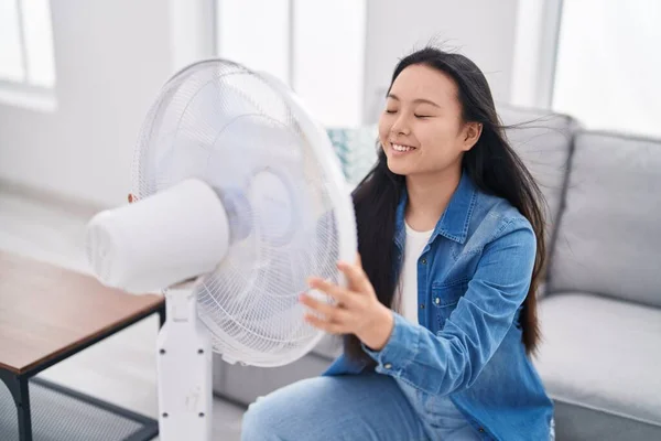 Young Chinese Woman Using Ventilator Sitting Sofa Home — Zdjęcie stockowe
