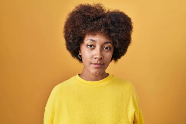 Młoda Afroamerykanka Stojąca Nad Żółtym Tłem Zrelaksowana Poważnym Wyrazem Twarzy — Zdjęcie stockowe